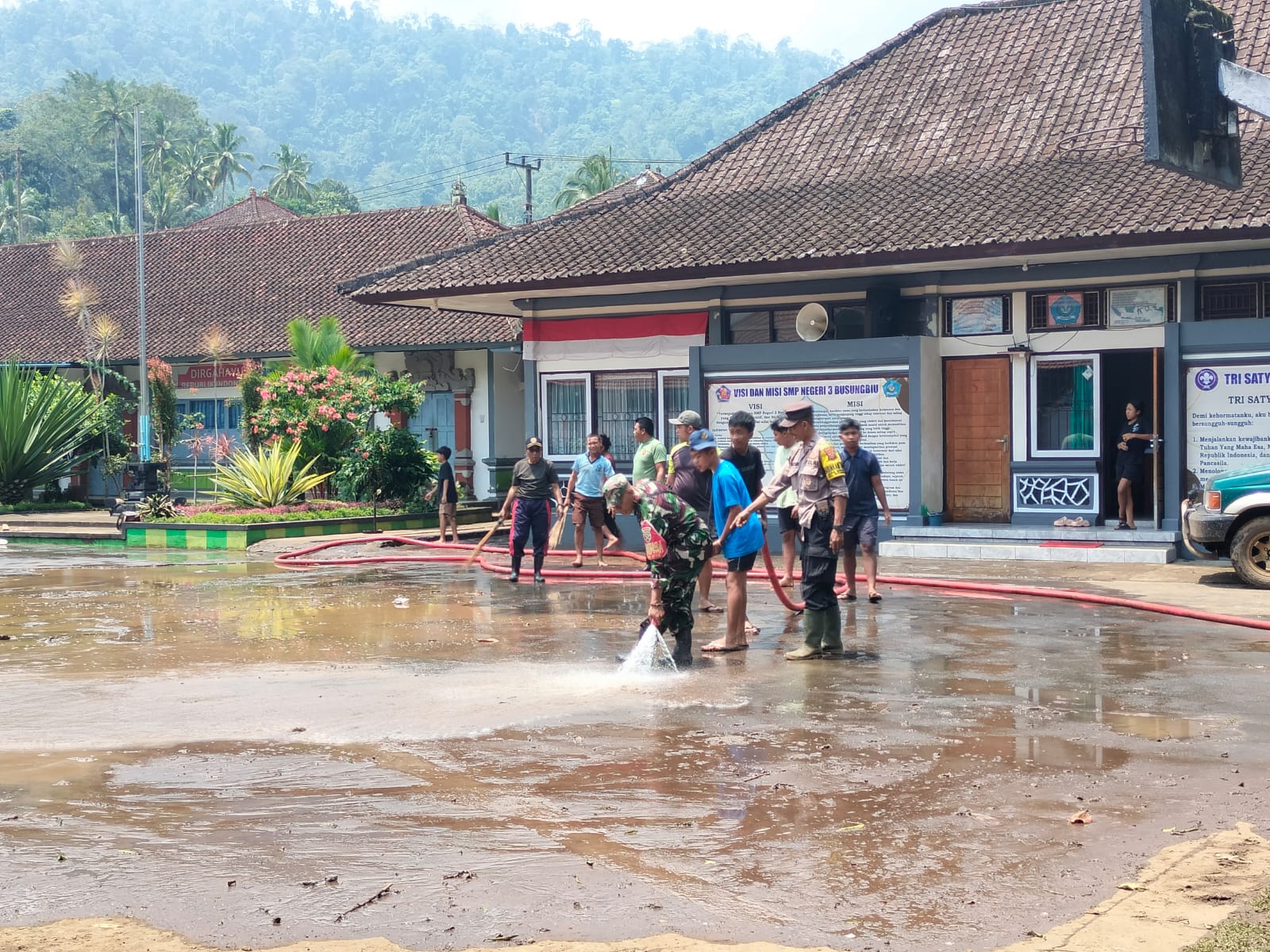 TERTUTUP LUMPUR: TNI, Polri, pemerintah desa, warga sekolah, dan siswa membersihkan lumpur yang menutupi halaman sekolah di SMPN 3 Busungbiu.