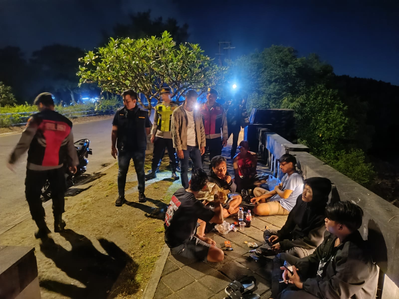 HIMBAUAN: Aparat kepolisian memberikan himbauan kepada sekelompok pemuda yang nongkrong di tepi jalan.