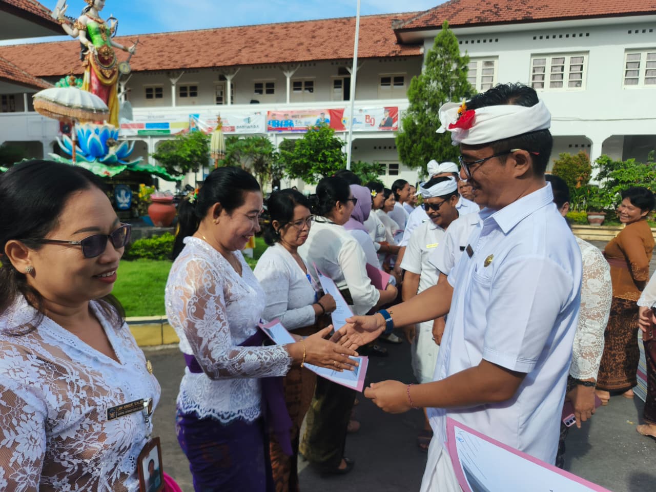 SERAHKAN SK: Kepala Disdikpora Buleleng, Ida Bagus Gde Surya Bharata (kanan) menyerahkan SPK perpanjangan masa hubungan kerja kepada para guru.