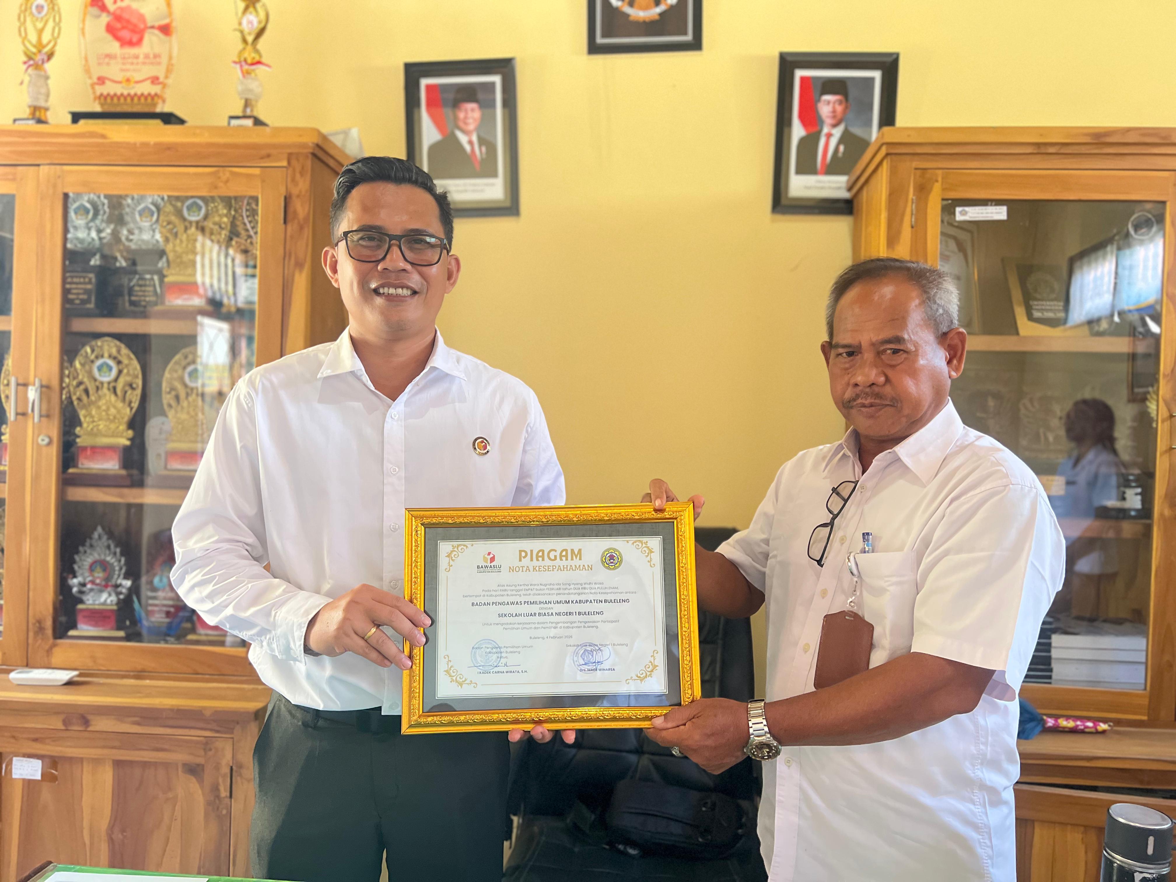 KERJASAMA: Ketua Bawaslu Buleleng, Kadek Carna Wirata (kiri) menandatangi MoU dengan Kepala SLBN 1 Buleleng, Made Winarsa (kanan).