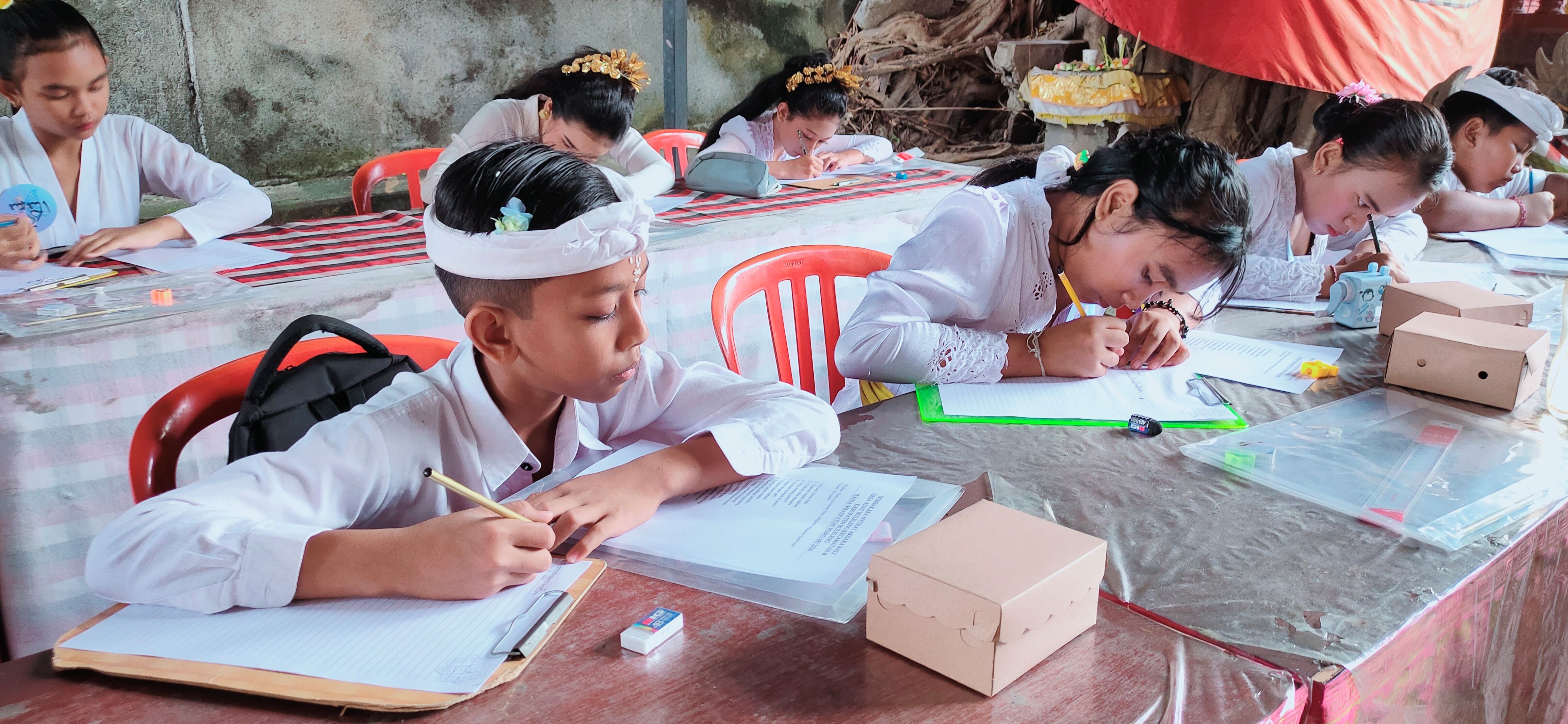 NYURAT AKSARA: Suasana lomba nyurat aksara yang melibatkan siswa SD di Desa Adat Buleleng.
