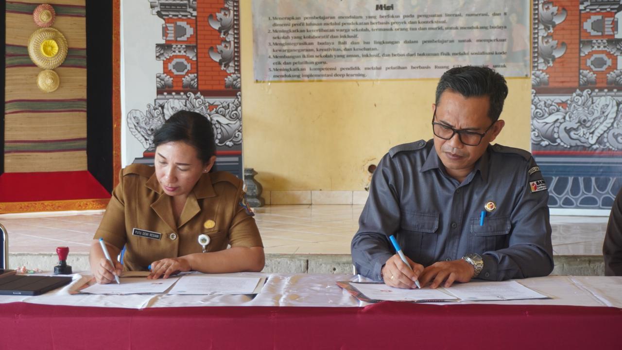 KERJASAMA: Ketua Bawaslu Buleleng, Kadek Carna Wirata (kanan) dan Kepala SLBN 2 Buleleng, Putu Dewi Resiani (kiri) menandatangani MoU pengawasan Pemilu dan Pilkada partisipatif bagi disabilitas.