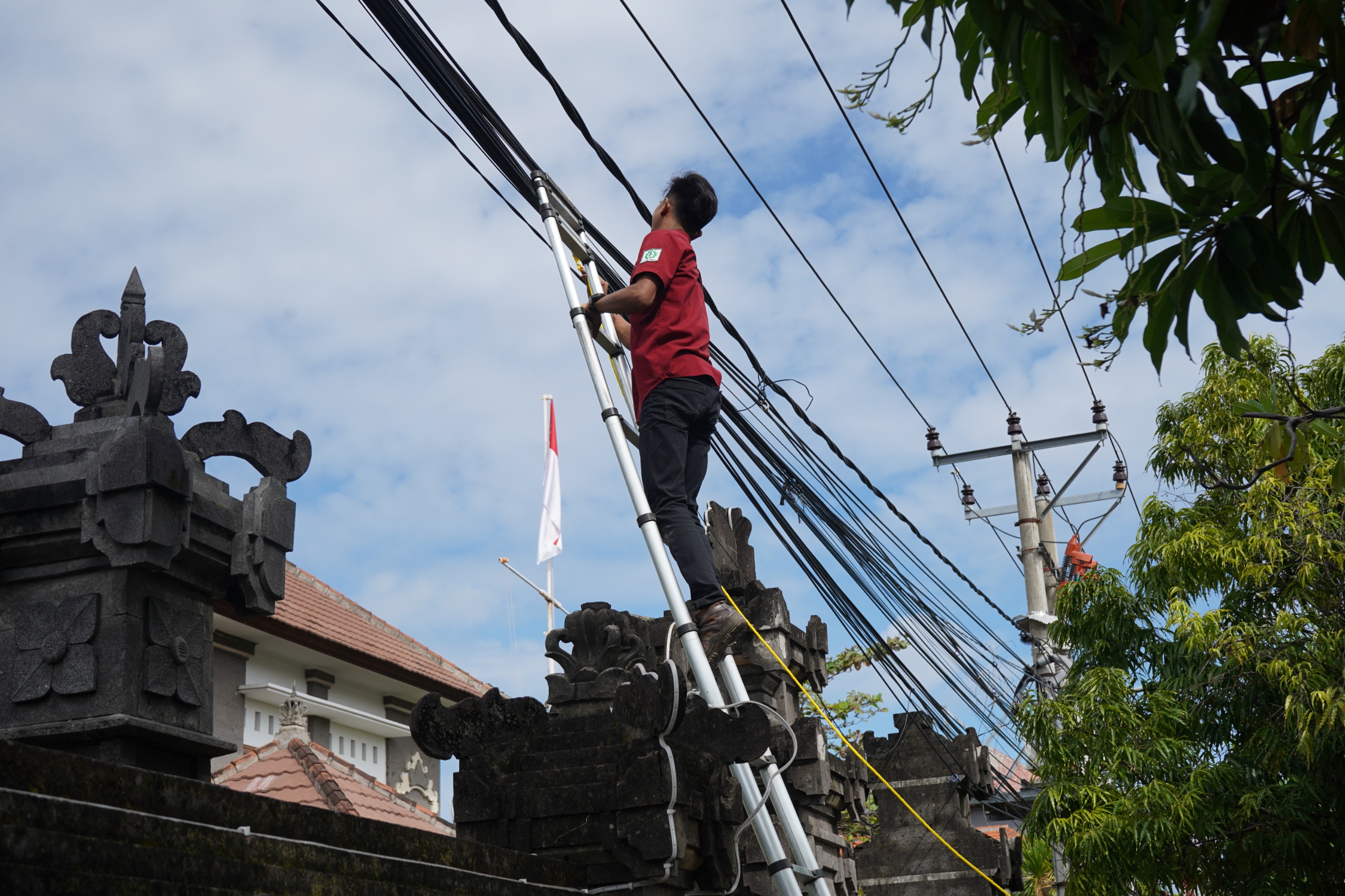 TATA KABEL: Proses penataan kabel internet fiber optik di Jalan Pramuka, Singaraja.