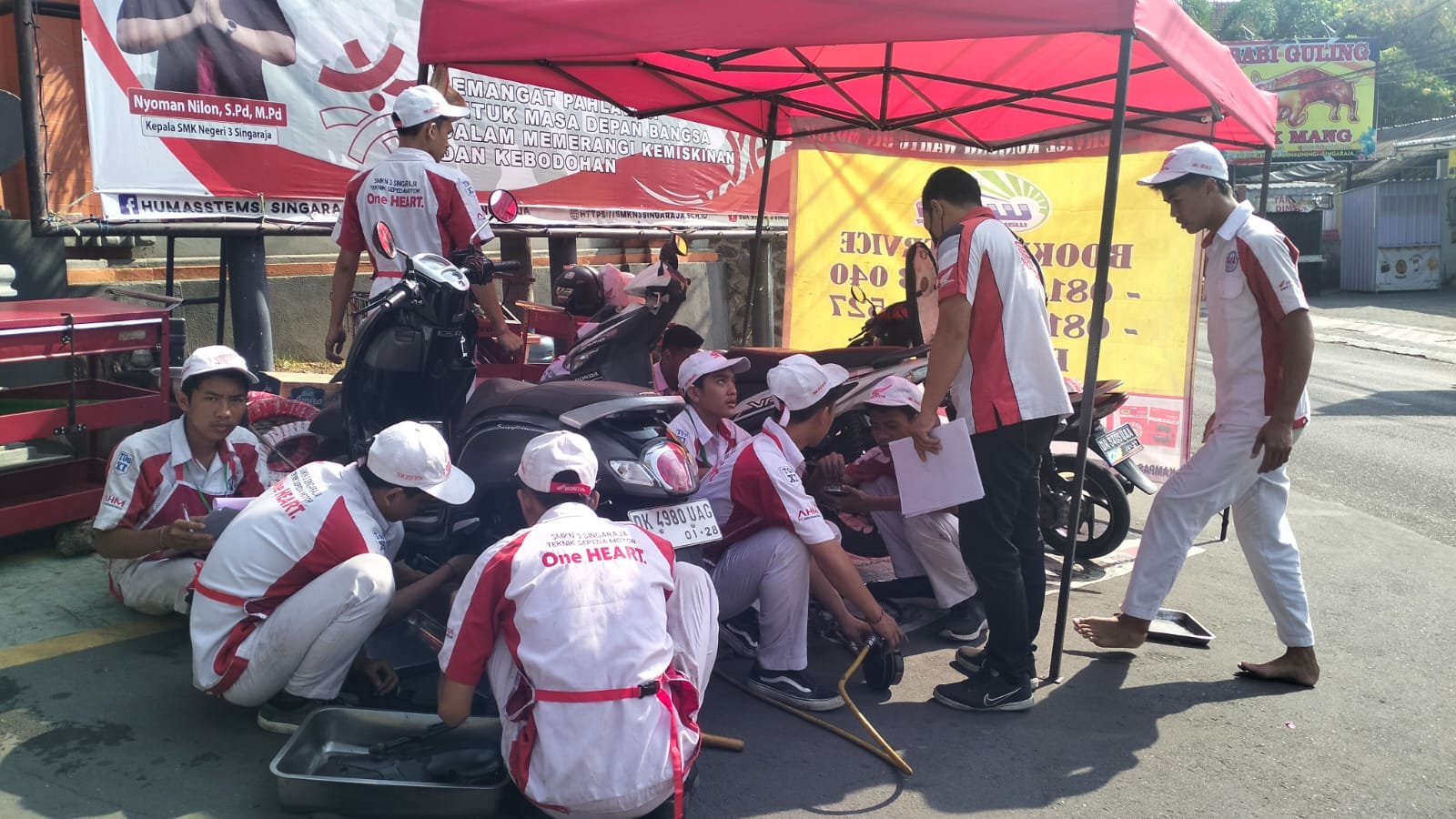 SERVICE KENDARAAN: Siswa jurusan Teknik Sepeda Motor saat melakukan service sepeda motor di teaching factory SMKN 3 Singaraja.