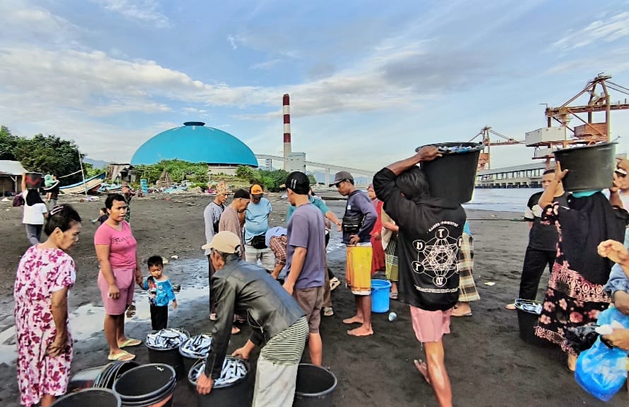 ANGKUT IKAN: Nelayan di Pantai Berombong mengangkut ikan hasil tangkapan.