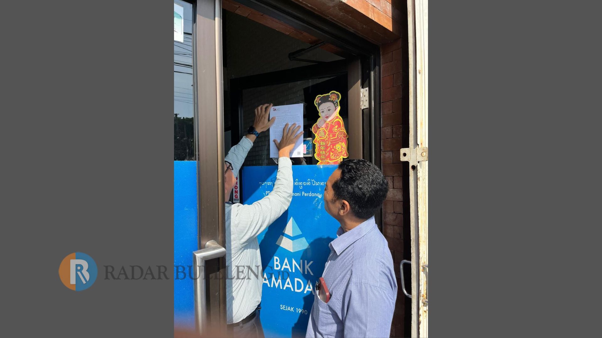 IZIN DICABUT: Petugas OJK memasang pengumuman pencabutan izin usaha BPR Kamadana di Kecamatan Kintamani, Bangli.