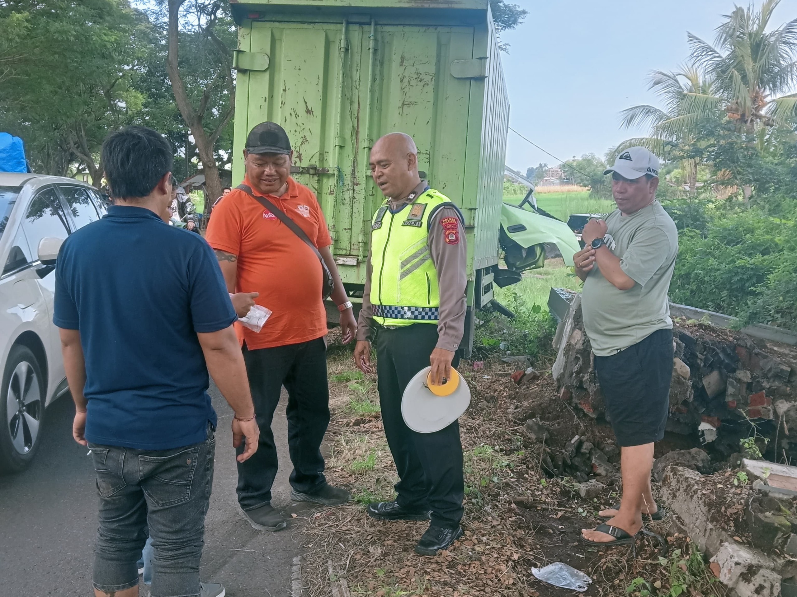 NGANTUK BIKIN CELAKA: Polisi mendatangi lokasi truk yang menabrak tapal batas antara Desa Temukus dan Desa Kaliasem.