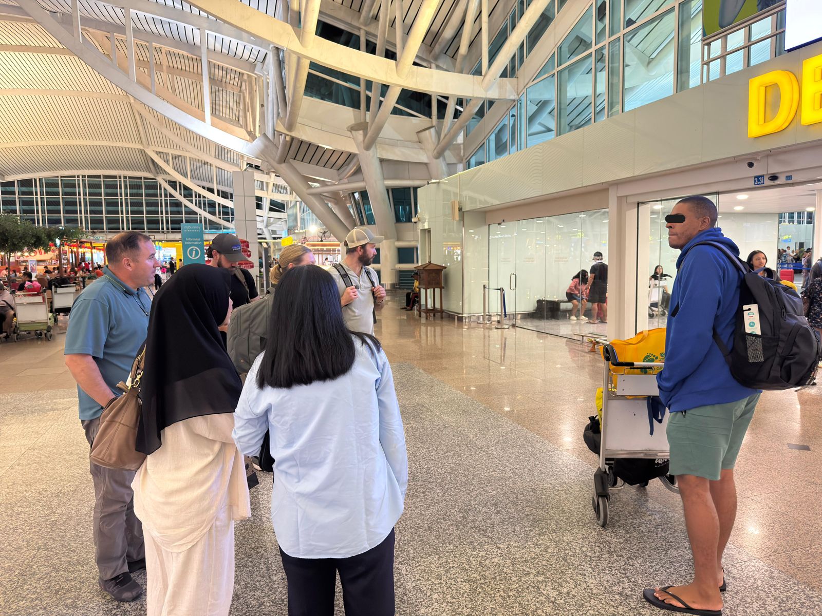 DEPORTASI: WNA asal Amerika Serikat, Tommy Schaefer (pakai hoodie biru) saat menjalani proses deportasi melalui Bandara Ngurah Rai.