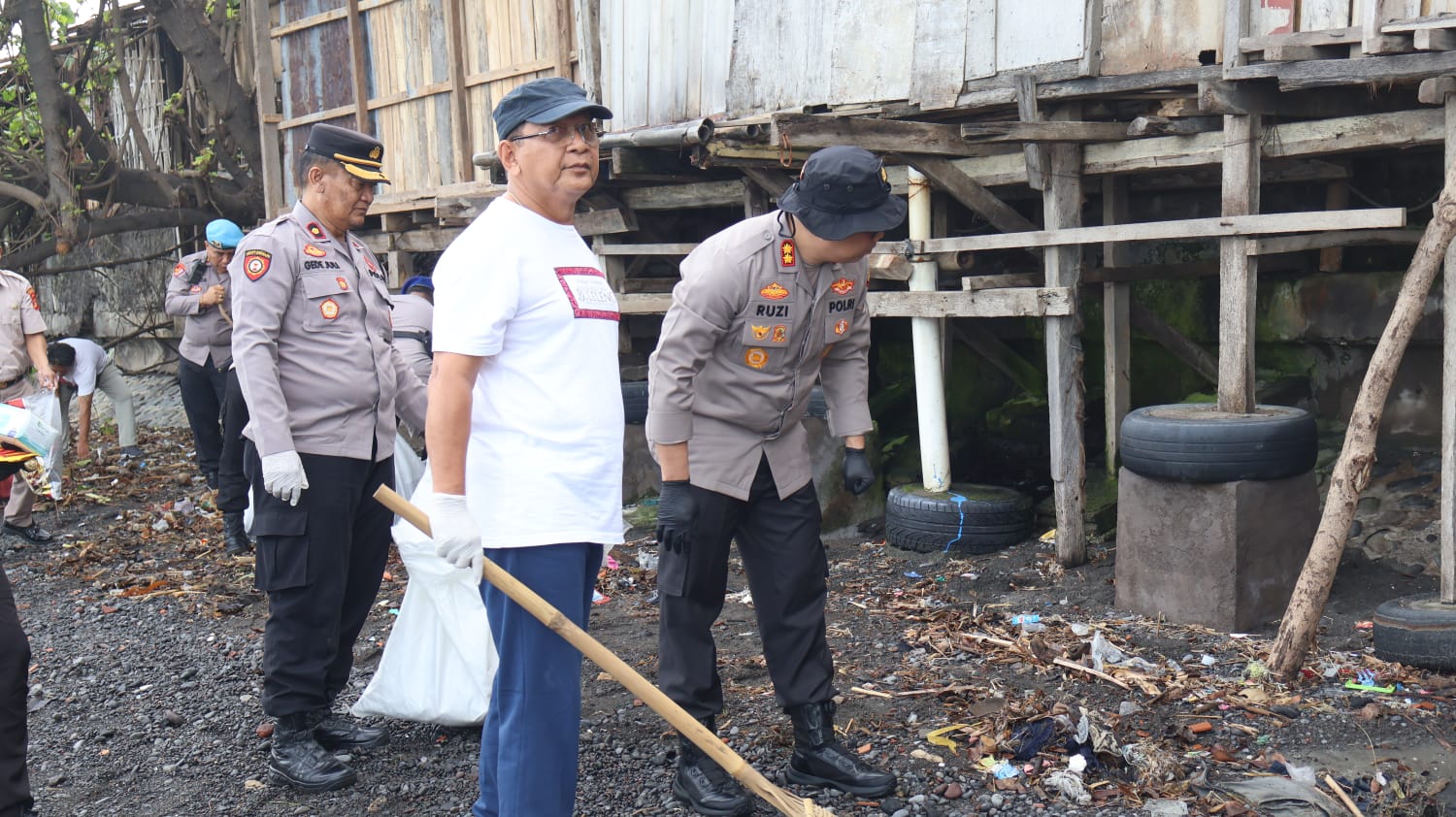 BERSIHKAN PANTAI: Bupati Buleleng, I Nyoman Sutjidra (baju putih) saat melakukan pembersihan sampah di kawasan Pantai Kampung Baru. Ia mendapati sejumlah bangunan liar di sana.