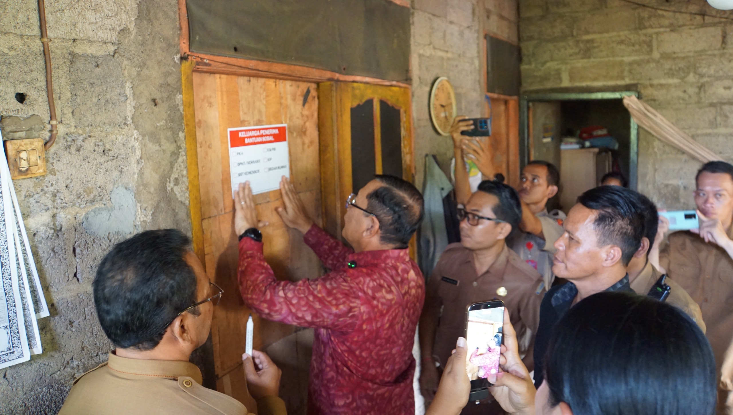PASANG STIKER: Bupati Buleleng, I Nyoman Sutjidra memasang stiker tanda penerima bantuan di Buleleng.