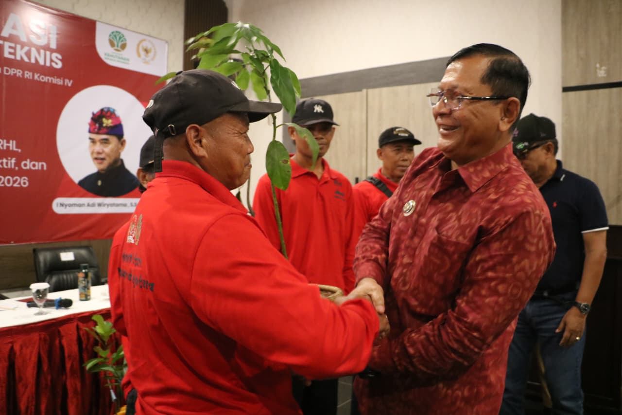 SERAHKAN BIBIT: Bupati Buleleng, I Nyoman Sutjidra (kanan) menyerahkan bibit buah kepada masyarakat di Seririt.