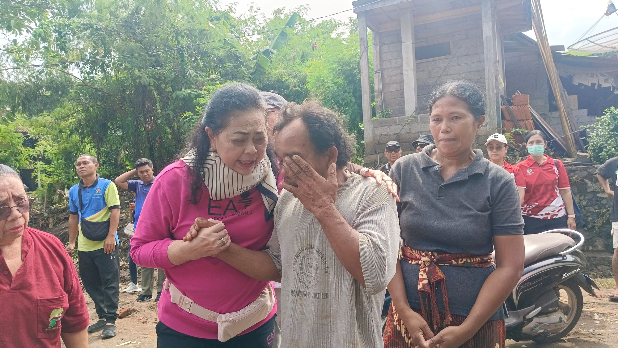 MENANGIS: Kadek Witana (baju abu-abu) menangis setiap kali mengingat peristiwa yang banjir bandang yang menyebabkan istri dan kedua anaknya hilang.
