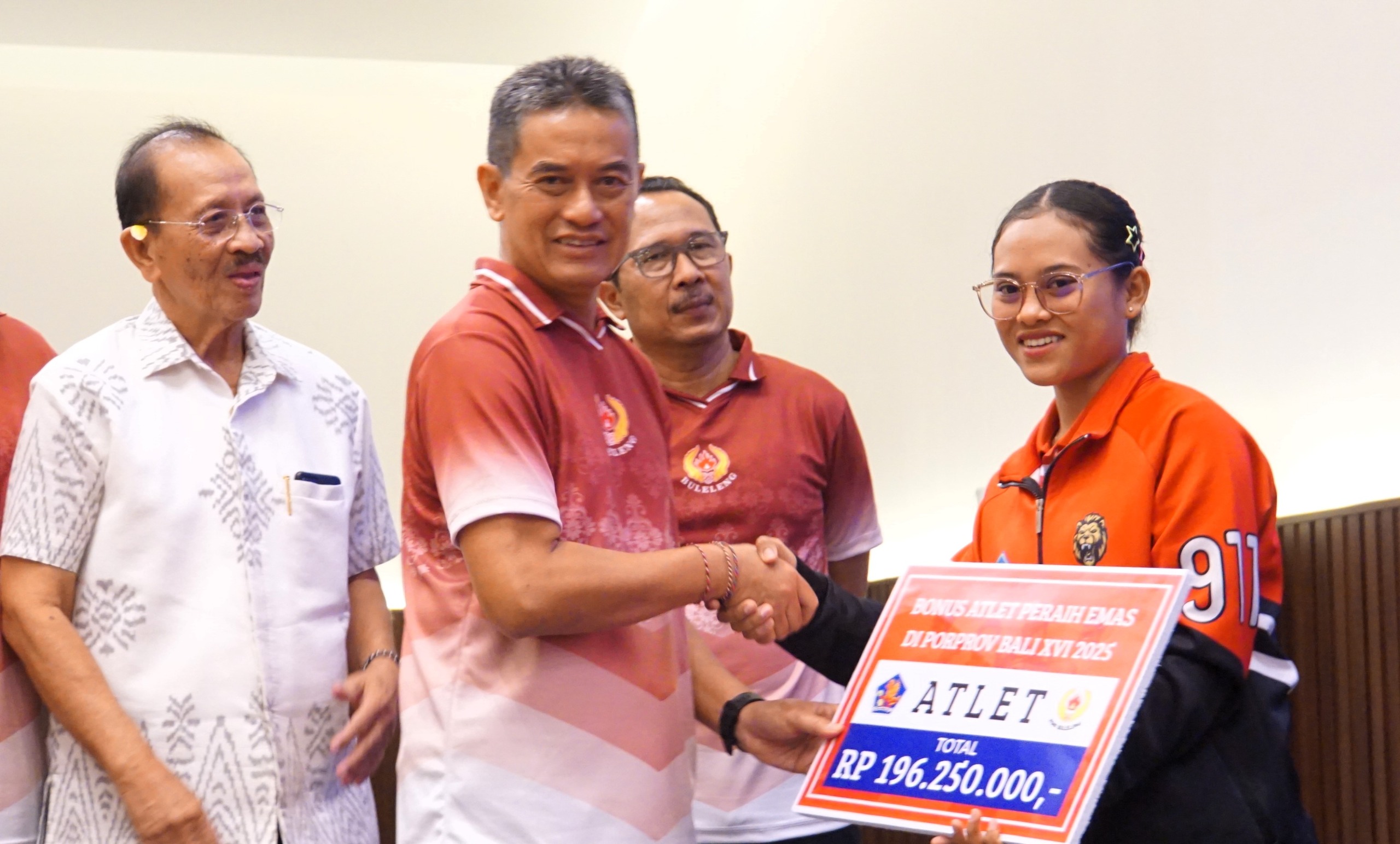 SERAHKAN BONUS: Ketua Umum KONI Buleleng yang juga Wakil Bupati Buleleng, Gede Supriatna menyerahkan bonus kepada atlet.