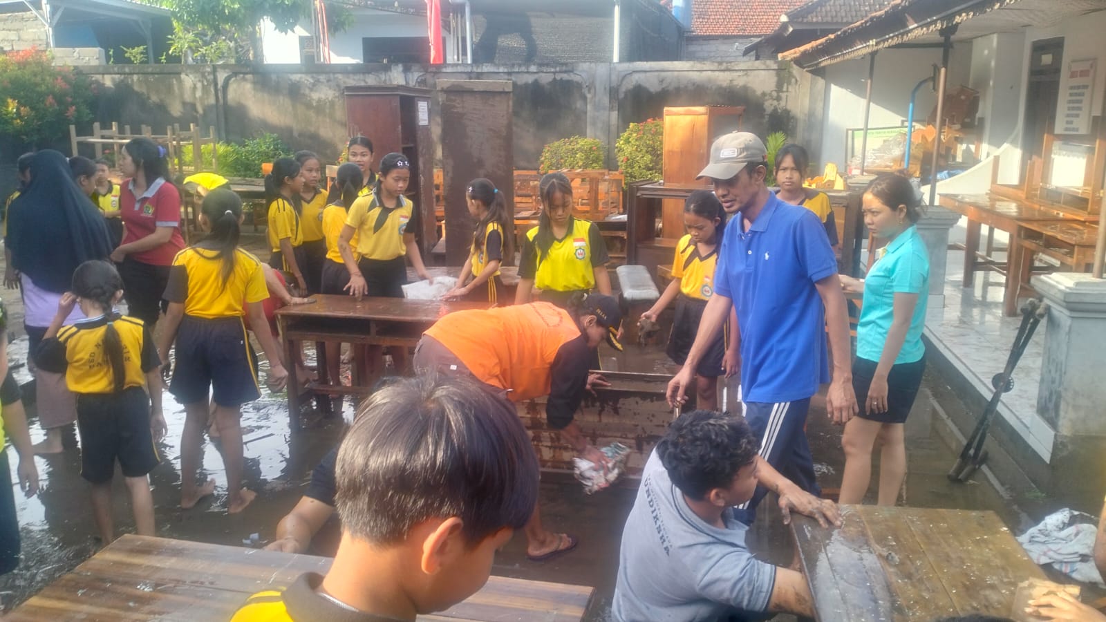 BERSIHKAN LUMPUR: Siswa bersama para guru di SDN 5 Banjar membersihkan lumpur yang merendam halaman imbas banjir bandang.