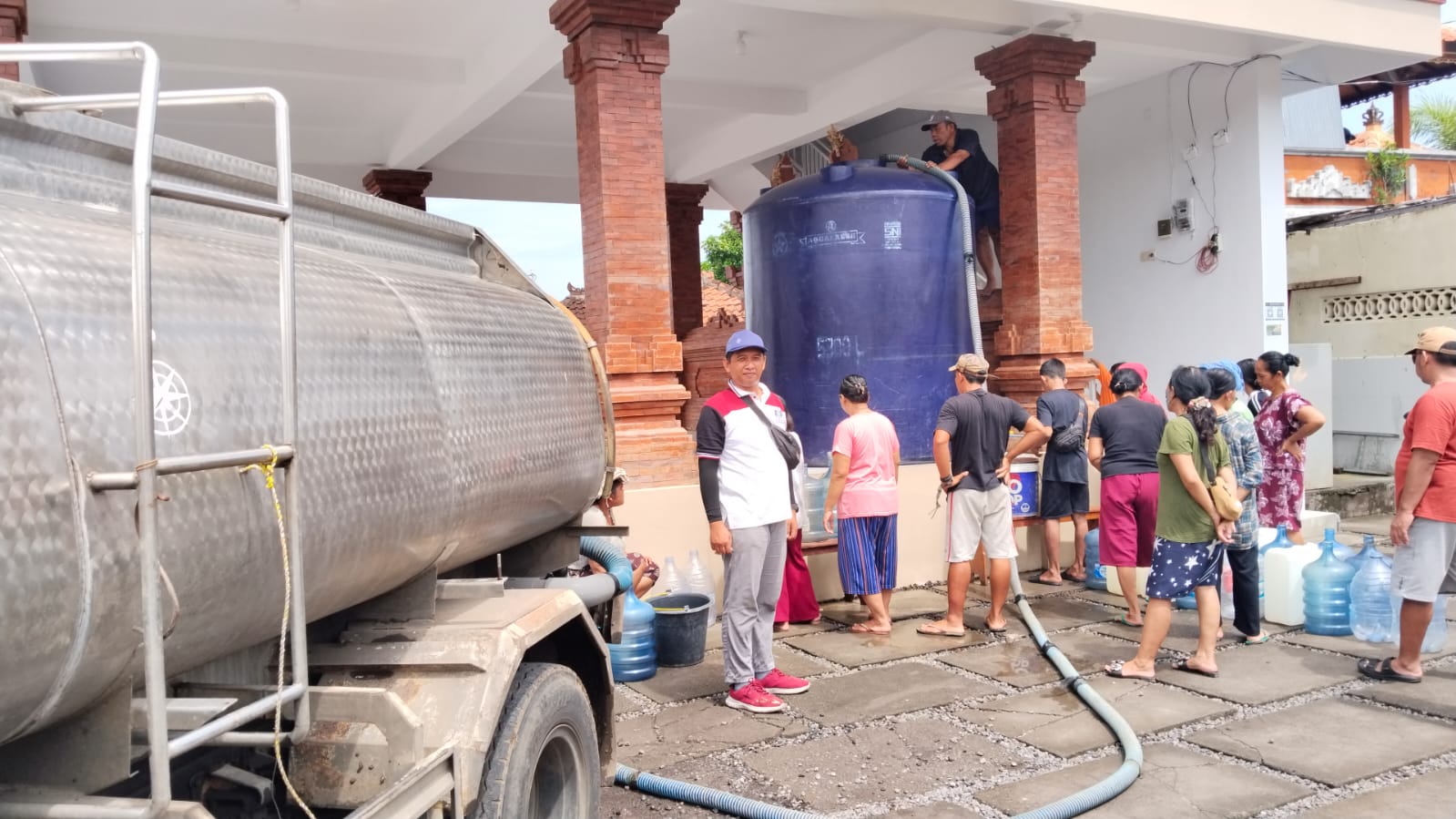 ANTRE AIR BERSIH: Proses penyaluran air bersih ke wilayah terdampak bencana di Desa Banjar, Buleleng.