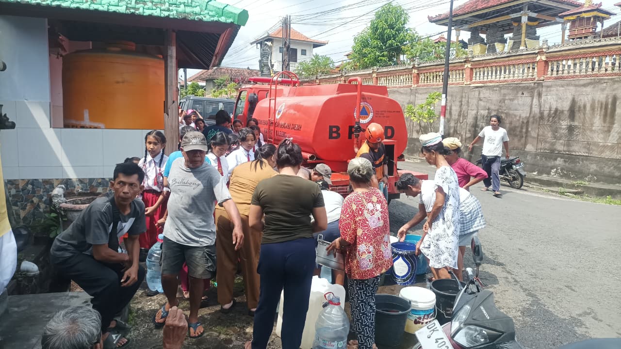 ANTRE AIR BERSIH: Warga di Desa Banjar Tegeha masih mengantre air bersih. Pipa air minum di 11 desa rusak imbas banjir bandang.
