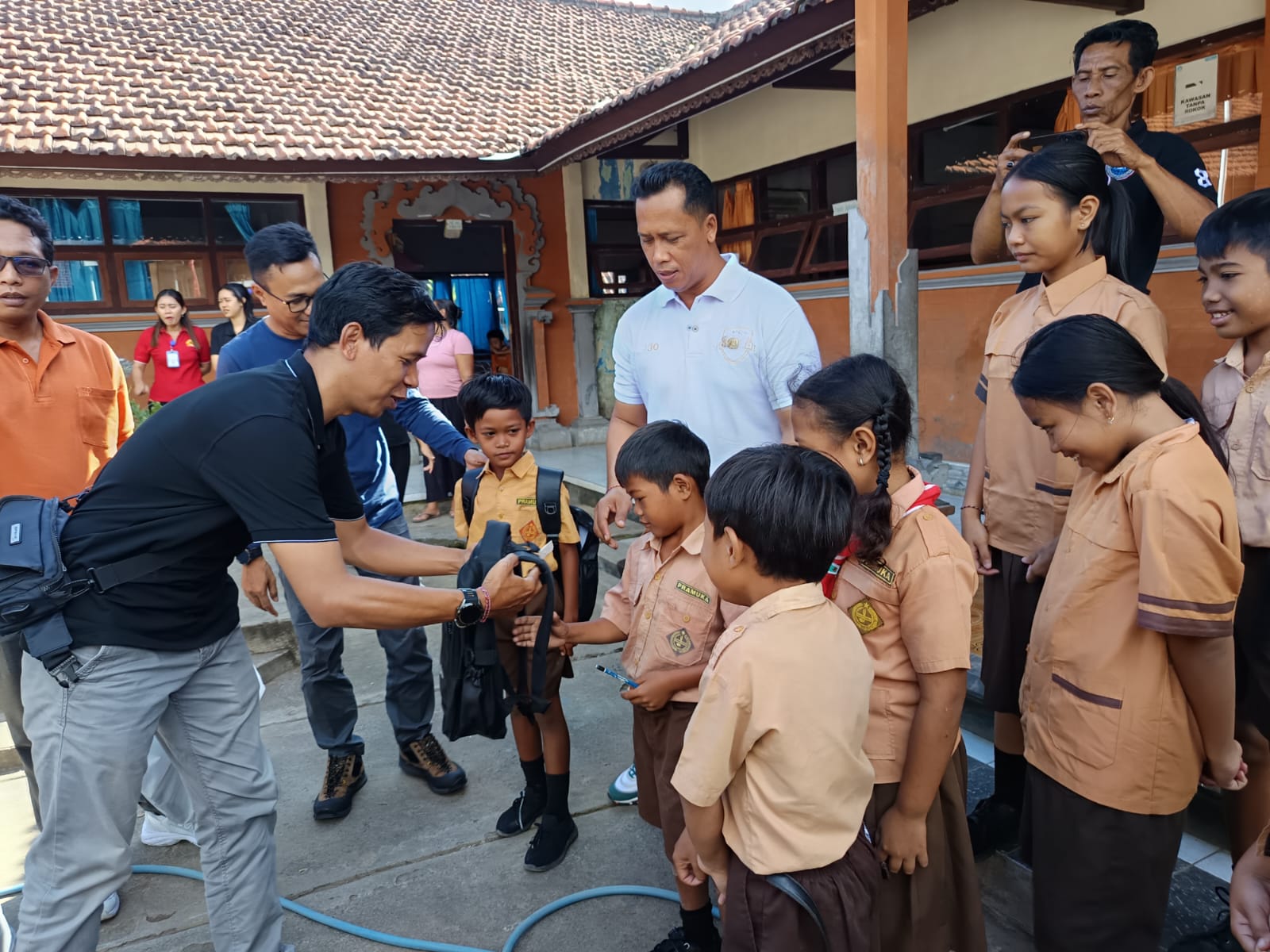 SERAHKAN BANTUAN: Para jurnalis di Buleleng menyerahkan bantuan kepada siswa SDN 5 Banjar yang terdampak banjir bandang.