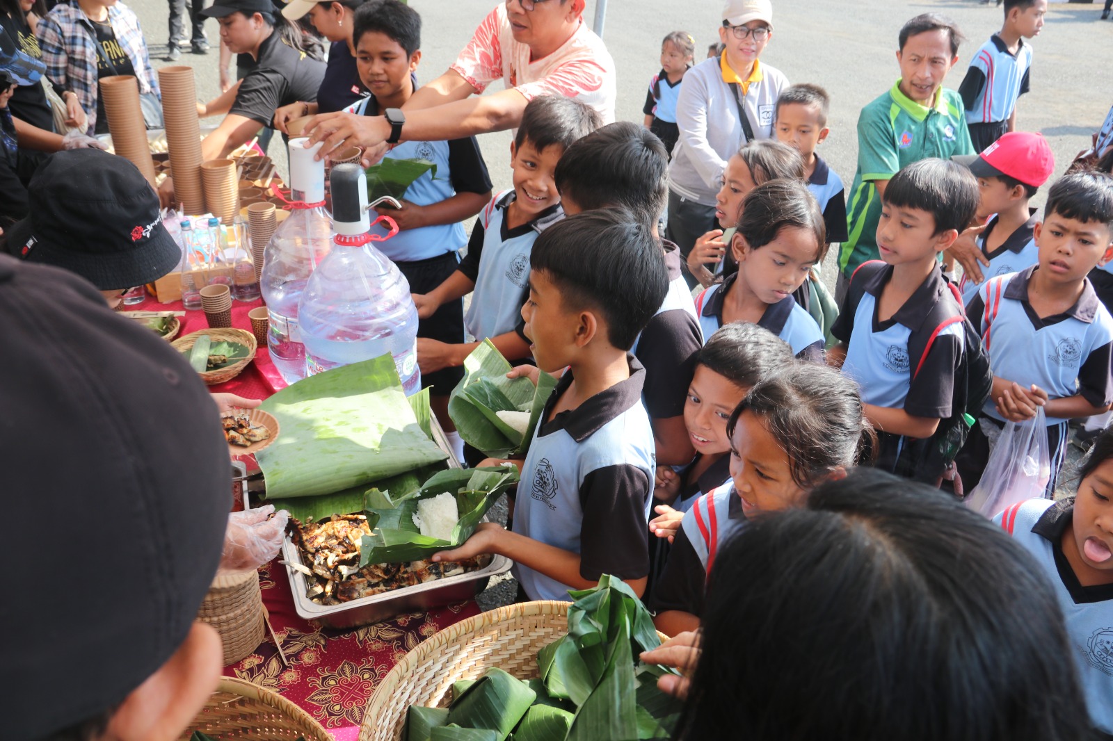 ANTRE DULU: Siswa mengantre untuk mendapatkan hidangan sate ikan dan bandeng bakar gratis. Berbagai jenis olahan ikan dibagikan gratis kepada warga serangkaian HUT ke-422 Kota Singaraja.