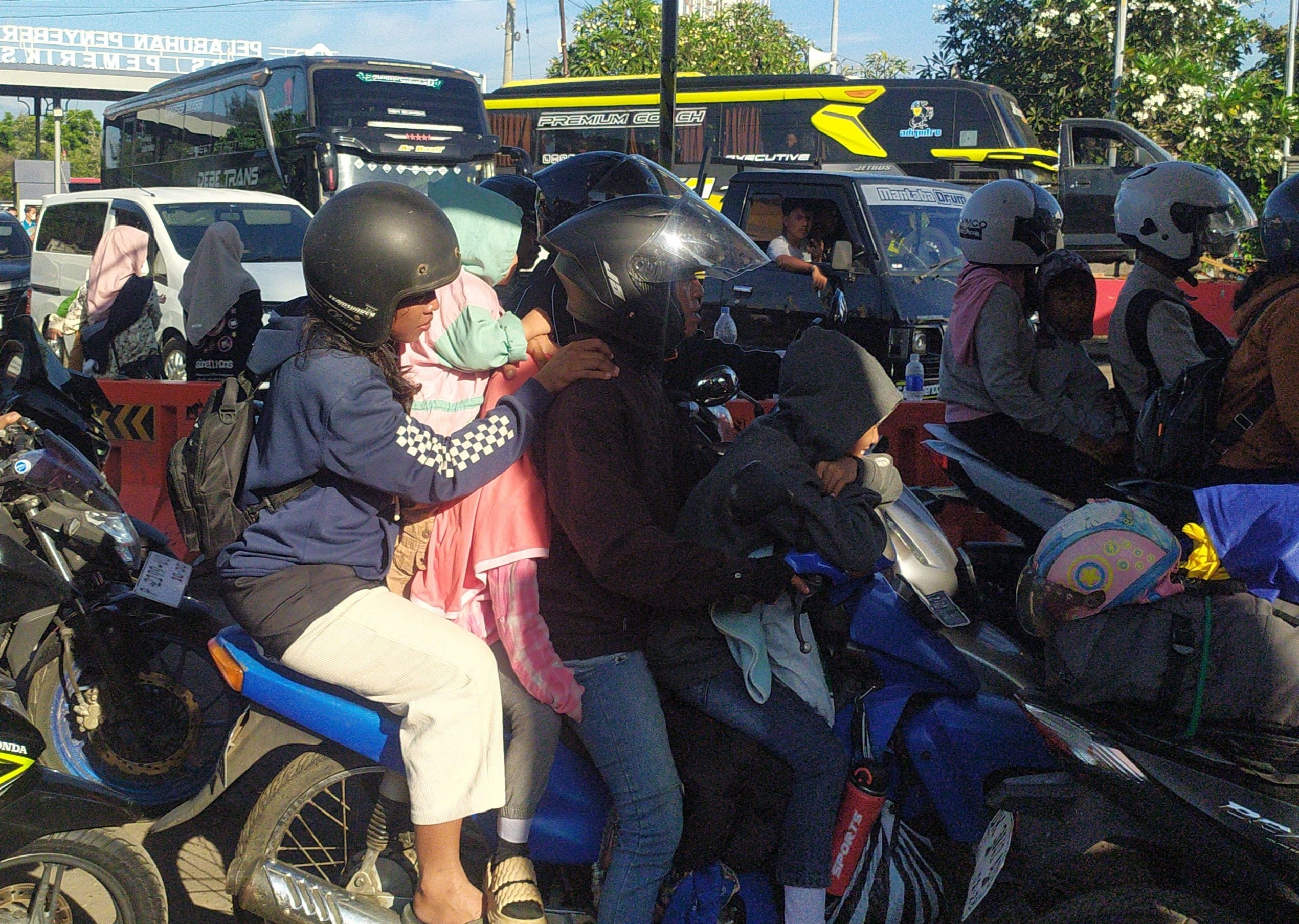 BOYONG KELUARGA: Seorang pemudik tampak memboyong istri dan ketiga anaknya. Mereka mudik menggunakan sepeda motor karena alasan biaya.