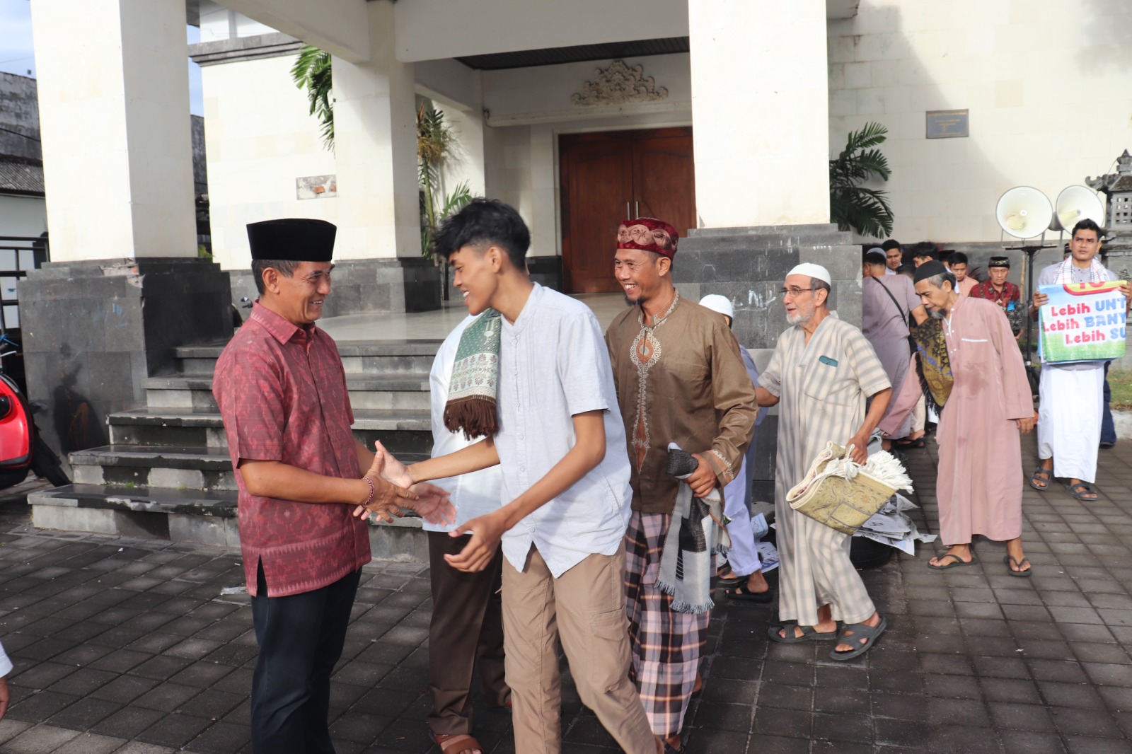SAPA UMAT: Wakil Bupati Buleleng, Gede Supriatna (kiri) menyapa umat muslim usai melaksanakan sholat Idul Fitri di kawasan Pelabuhan Tua Buleleng pada Jumat (20/3/2026).