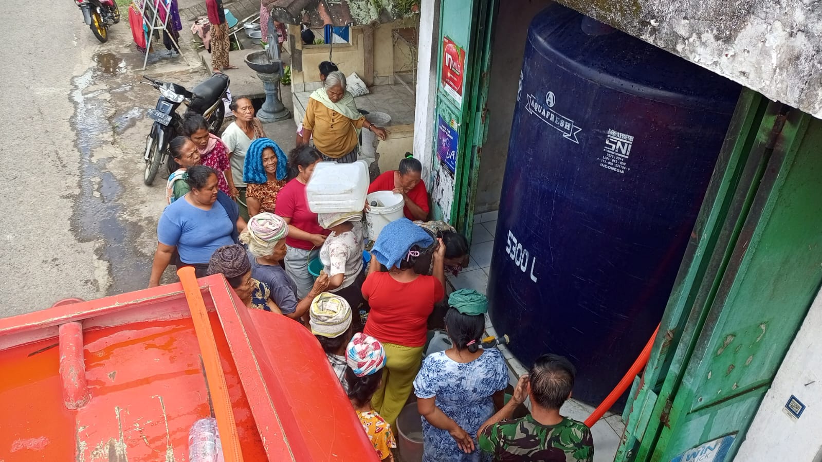 ANTRE AIR: Warga di Desa Tirtasari, Buleleng, mengantre air bersih. Jaringan pipa rusak imbas banjir bandang.