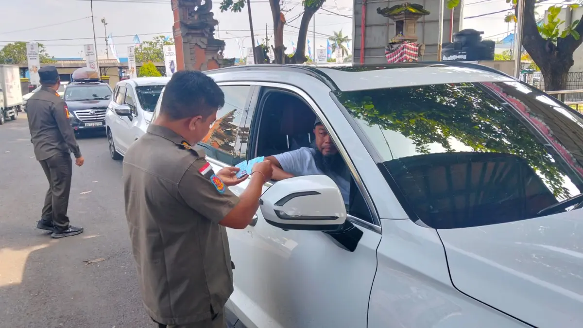 LAKUKAN PENGAWASAN: Personel Pol PP Jembrana melakukan pengawasan identitas bagi warga yang baru datang dari Pulau Jawa. (M. Basir/Radar Bali)