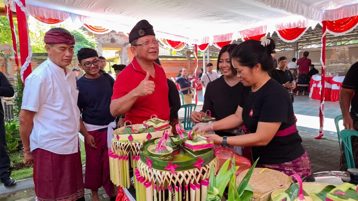 NGELAWAR: Bupati Buleleng, I Nyoman Sutjidra (pakai baju merah) melihat proses penyajian hidangan lawar. (Pemkab Buleleng)