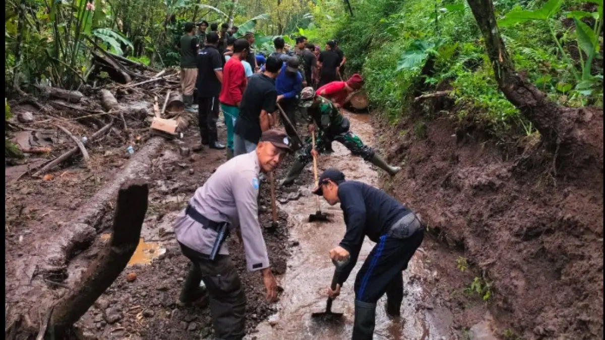LONGSOR: Warga bahu membahu membersihkan material longsor yang menutup akses jalan di Desa Gitgit, Buleleng. (BPBD Buleleng)