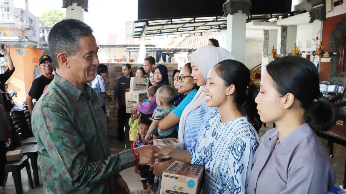 SERAHKAN BANTUAN: Wakil Bupati Buleleng, Gede Supriatna (kiri) menyerahkan bantuan kepada ibu hamil dan balita di Kelurahan Banyuasri. (Pemkab Buleleng)
