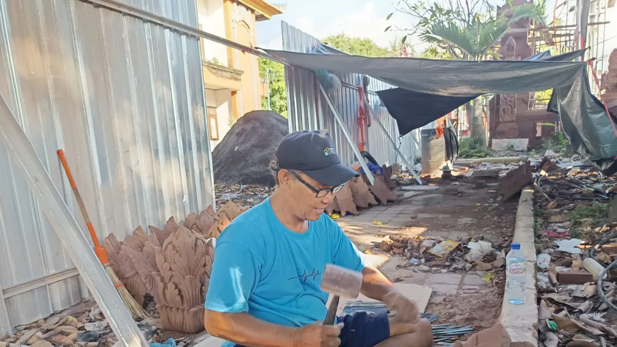 KERJAKAN UKIRAN: Seorang perajin tampak mengukir paras abasan untuk penataan titik nol Kota Singaraja. (Eka Prasetya/Radar Buleleng)