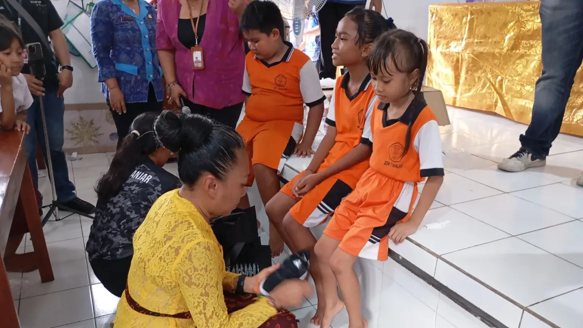 SEMRINGAH: Para siswa di SDN 7 Banjar gembira menerima bantuan sepatu. Bantuan tersebut diserahkan oleh Anggota DPD RI asal Bali, Ni Luh Djelantik. (Francelino Junior/Radar Buleleng)