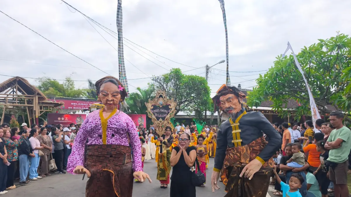 DAWANG-DAWANG: Salah seorang pengunjung Pesta Kesenian Bali (PKB) berfoto bersama dengan dawang-dawang yang dibawakan Komunitas Seni Rare Kual, Buleleng, pada ajang PKB 2026. (Pemkab Buleleng)