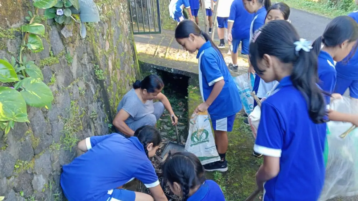 BERSIHKAN SAMPAH: Siswa di Desa Gobleg membersihkan sampah di selokan. (Pemdes Gobleg)