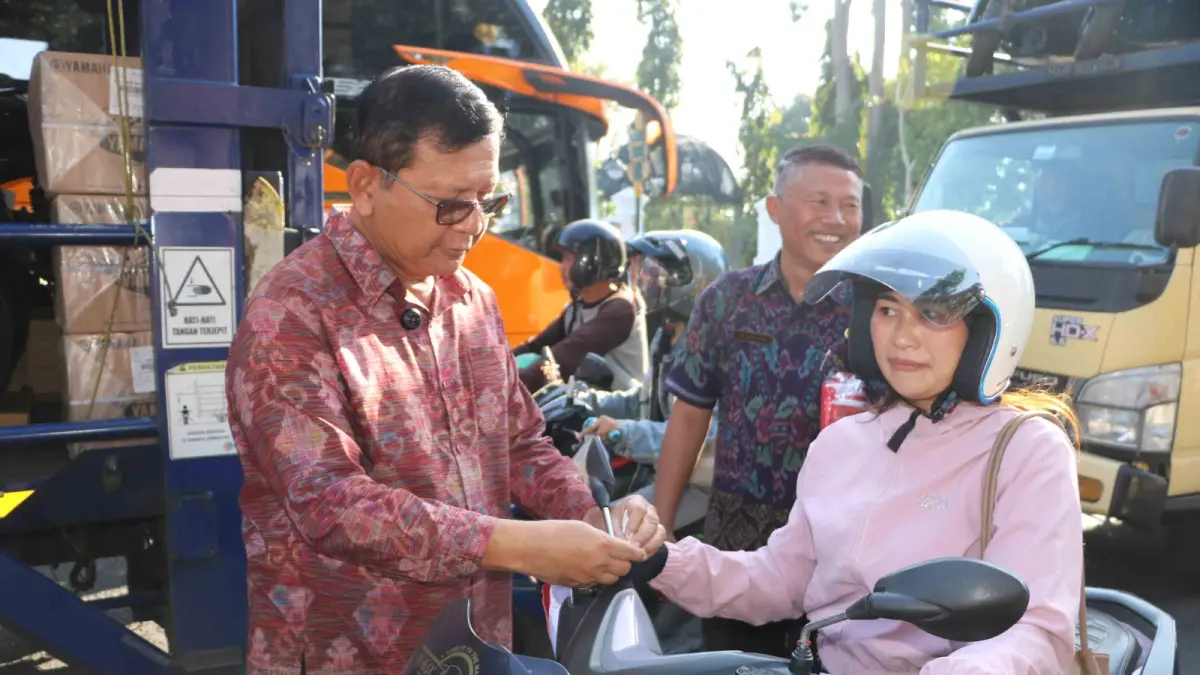 BAGIKAN BENDERA: Bupati Buleleng, I Nyoman Sutjidra membagikan bendera kepada warga di Kota Singaraja. (Pemkab Buleleng)