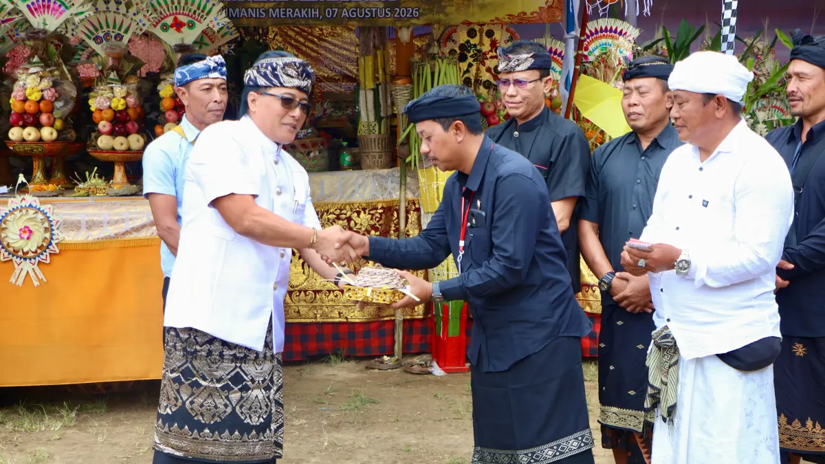 DESA ADAT: Wakil Gubernur Bali, Nyoman  Giri Prasta (kiri) menyerahkan punia kepada Desa Adat Mengandang yang menggelar ngaben massal. (Pemprov Bali)