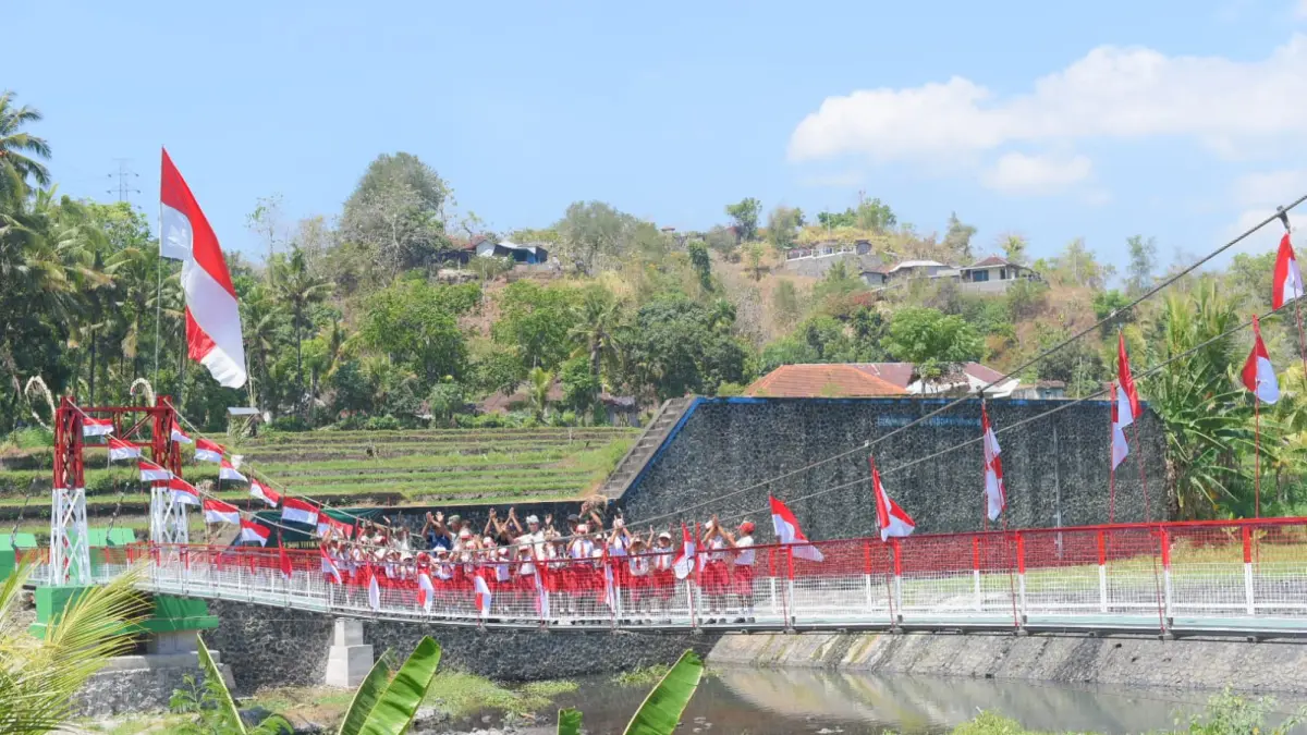JEMBATAN PENYEBERANGAN: Jembatan gantung yang membentang di Tukad Saba. Jembatan itu kini dimanfaatkan warga dan siswa di SDN 5 Ringdikit. (Kodam IX/Udayana)