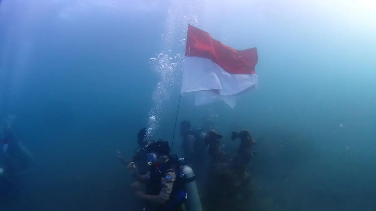 BAWAH AIR: Pengibaran bendera dari bawah air di Pantai Kerobokan, Buleleng. (Pramuka Saka Bahari)