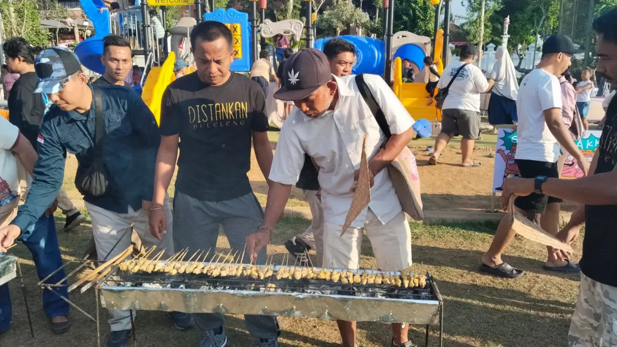 SATE GRATIS: Staf Distankan Buleleng memanggang sate yang dibagikan kepada masyarakat Buleleng. (Pemkab Buleleng)