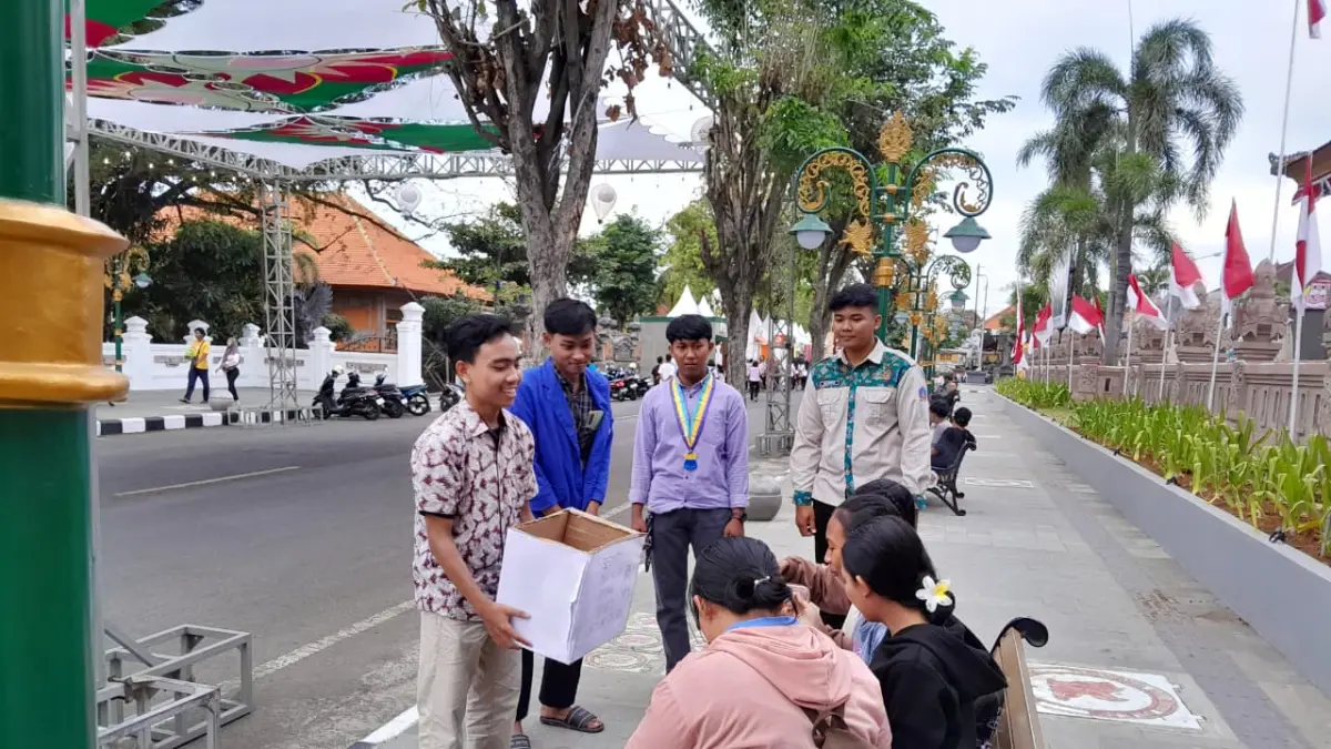 GALANG DONASI: Aksi mahasiswa Buleleng menggalang donasi warga di kawasan Praja Mandala Singa Ambara Raja. (Cipayung Plus Buleleng)