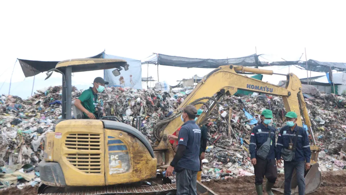 MENGGUNUNG: Petugas kebersihan di TPA Bengkala menggunakan alat berat untuk menata timbunan sampah. (Pemkab Buleleng)