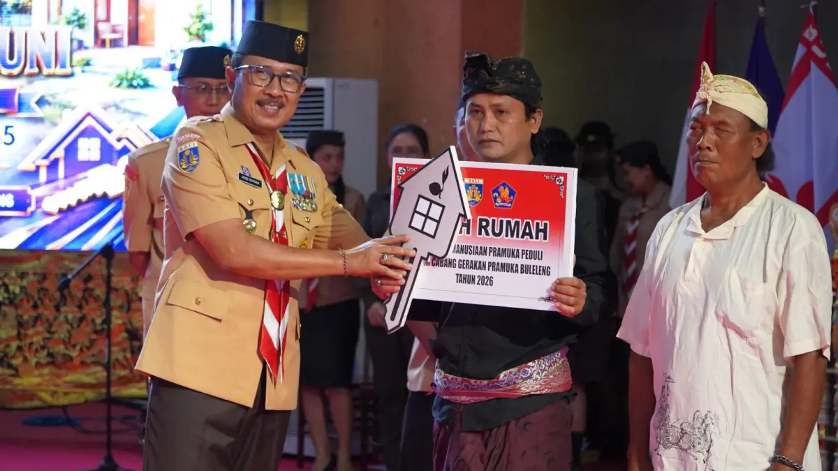 BEDAH RUMAH: Ketua Kwartir Cabang Gerakan Pramuka Buleleng, Gede Suyasa (kiri) menyerahkan bantuan bedah rumah kepada dua keluarga tidak mampu di Buleleng. (Pemkab Buleleng)