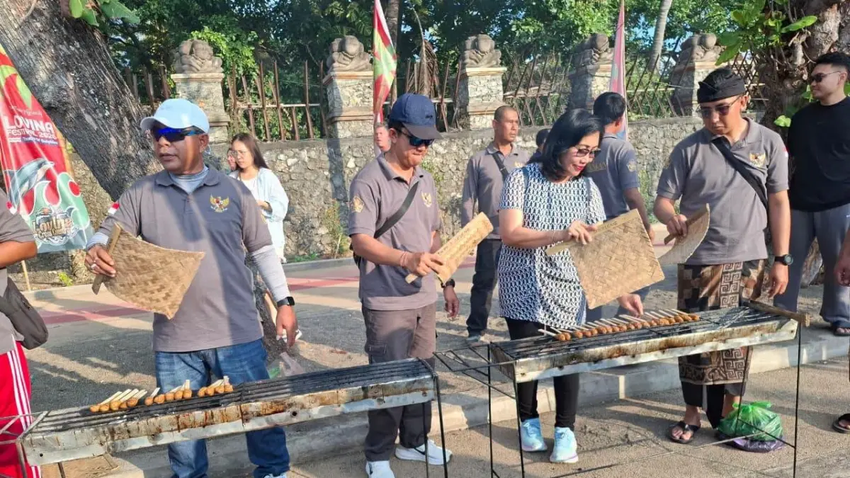 BAGI HIDANGAN GRATIS: Tim Distankan Buleleng saat memasak sate ikan di Pantai Lovina beberapa waktu lalu. Sate ikan itu dibagikan secara gratis. (Pemkab Buleleng)