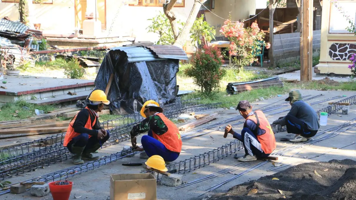 PERBAIKI SEKOLAH: Sejumlah buruh bangunan terlihat melakukan pekerjaan rehab ruang kelas di SDN 2 Ringdikit, Kecamatan Seririt. (Pemkab Buleleng)
