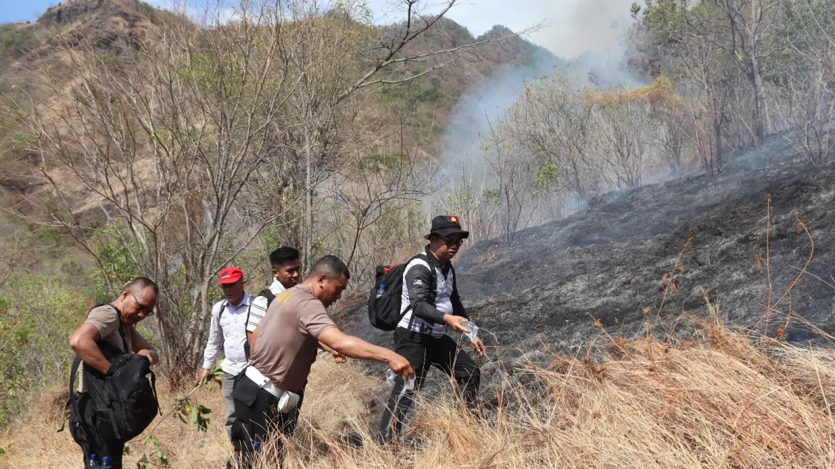 KEBAKARAN LAHAN: Aparat kepolisian berupaya memadamkan api yang membakar lahan kering di Buleleng. (Polres Buleleng)