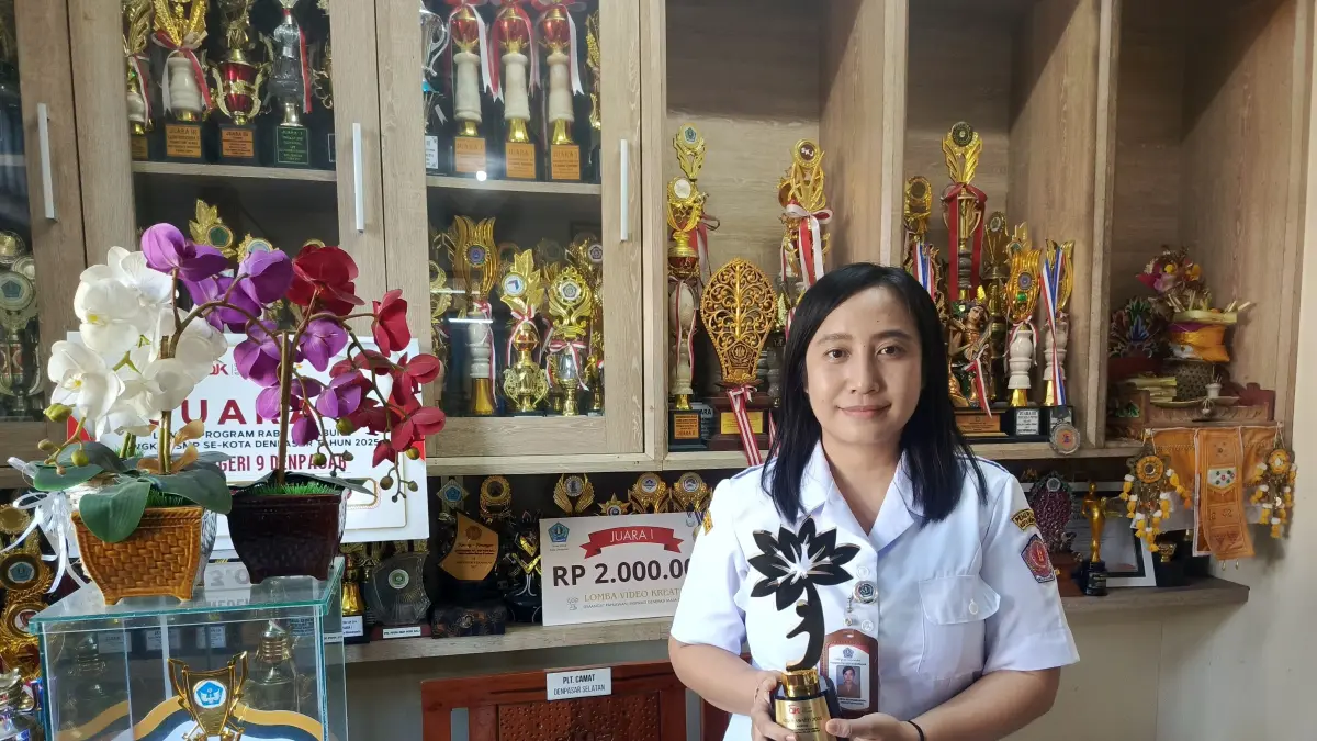 BERBUAH PRESTASI: Kepala SMPN 9 Denpasar, Andromeda Ken Prabuhening menunjukkan trofi dari Otoritas Jasa Keuangan (OJK). Program Siswa Rabu Menabung berbuah prestasi bagi sekolah. (I Wayan Widyantara/Radar Bali)