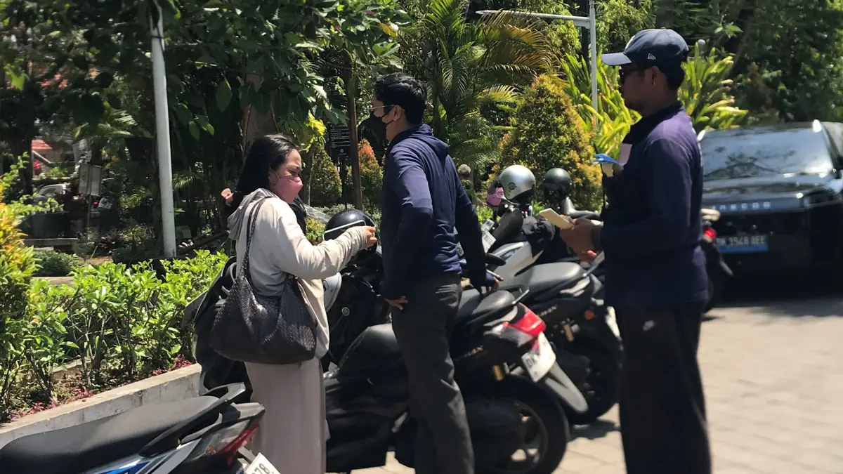 JURU PARKIR: Salah seorang juru parkir yang bertugas di kawasan Renon, Denpasar. (Miftahuddin M. Halim/Radar Bali)