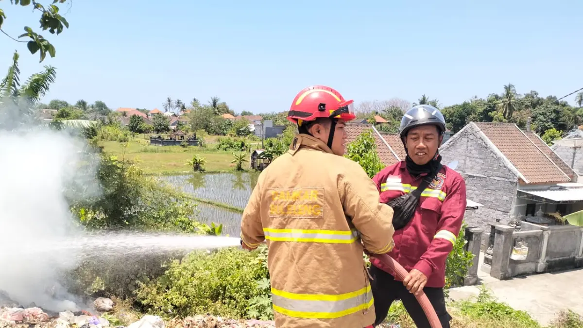 PADAMKAN API: Petugas pemadam kebakaran memadamkan api yang membakar tumpukan sampah di TPS Desa Sulanyah, Kecamatan Seririt. (Dinas Pemadam Kebakaran Buleleng)