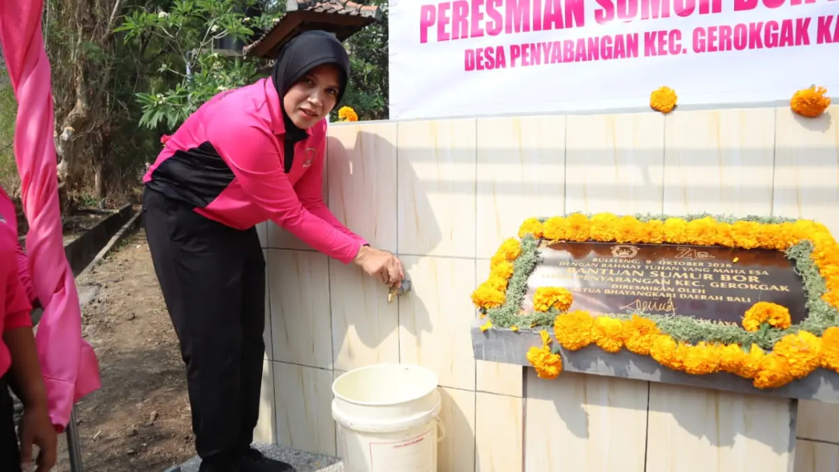 BANTU AIR BERSIH:  Ketua Bhayangkari Cabang Buleleng, Ny. Arini Gusman, menyalakan keran air bersih di SMPN 4 Gerokgak. (Polres Buleleng)