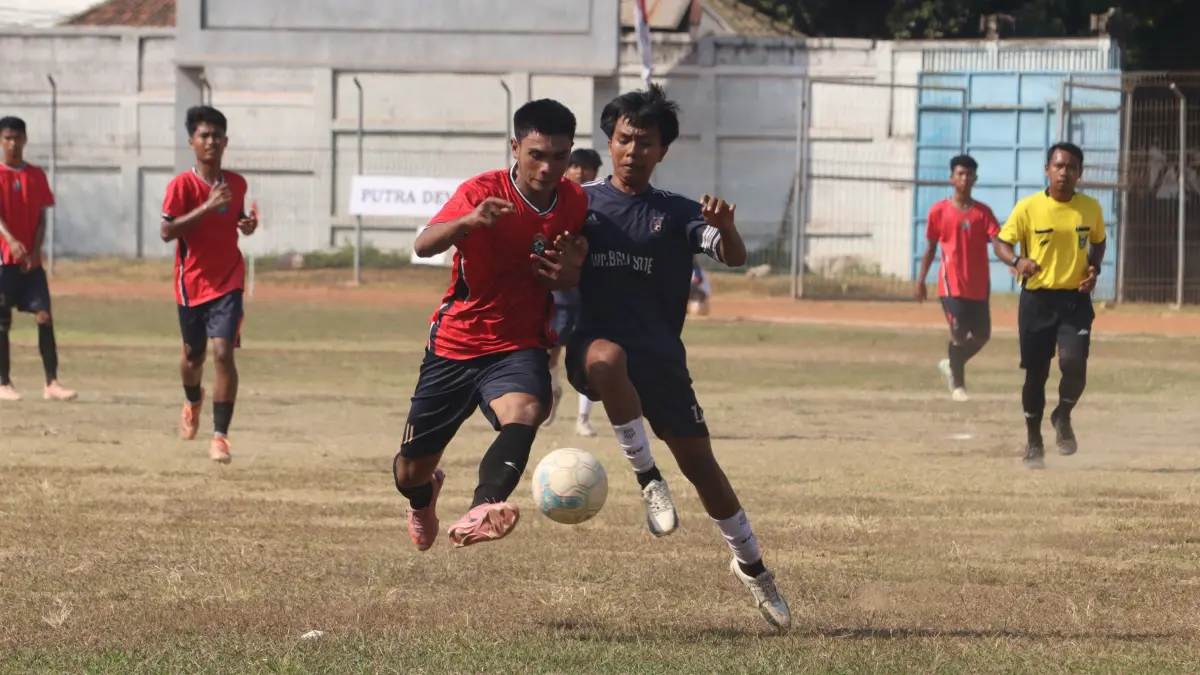 MENUJU SEMI FINAL: Pemain Putra Devata (merah) berebut bola dengan pemain Satria Muda Pengulon (biru) dalam pertandingan sepakbola Bupati Buleleng Cup 2026 di Stadion Mayor Metra,  Singaraja, Jumat (16/10/2026). (Eka Prasetya/Radar Buleleng)