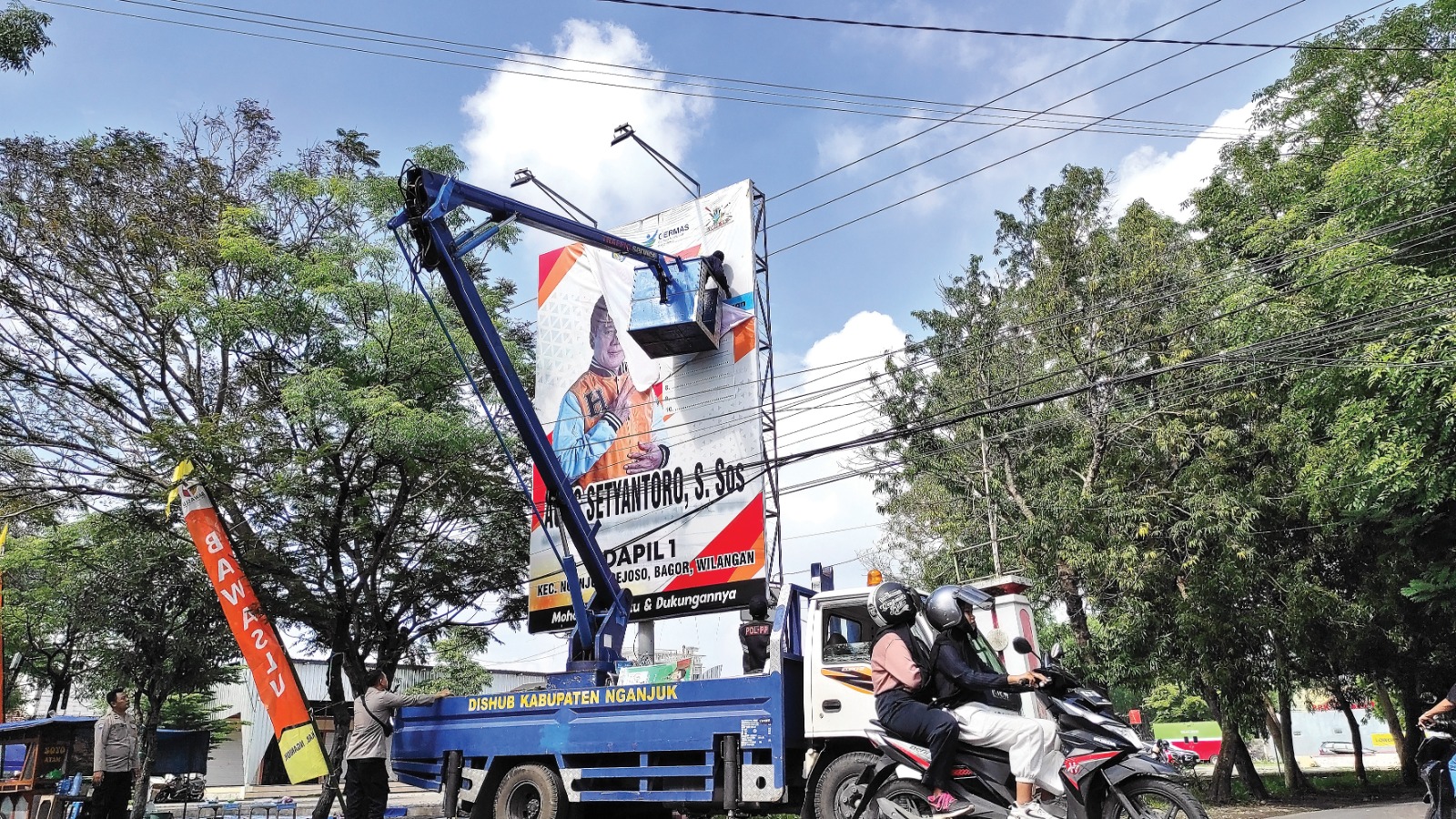 MASA TENANG: Petugas gabungan menurunkan baliho menggunakan mobil khusus dari dinas perhubungan di sekitar GOR Bung Karno, kemarin. Bawaslu jadikan catatan pelanggaran.